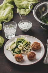 Chicken meat balls with zucchini salad and green peas, with garlic-yogurt sauce.