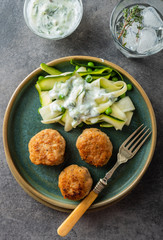 Chicken meat balls with zucchini salad and green peas, with garlic-yogurt sauce.