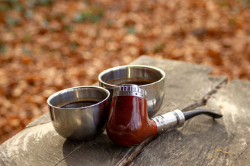 e-pipe with blurred background and cup of coffee in natural ambient. Electronic cigarette,...