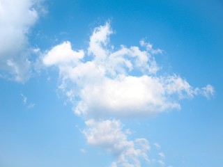 Clear blue sky with scattered white clouds creating beautiful patterns above horizon. Fresh...
