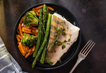 Pike perch fillet with asparagus, broccoli and carrots. Fried fish with stewed greens
