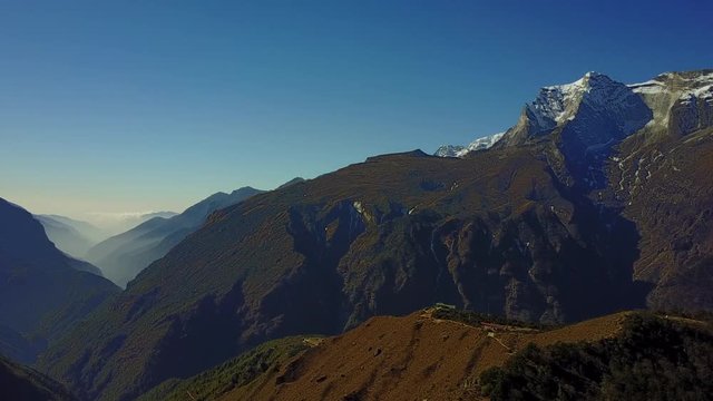 Aerial video of a foggy valley and snow-ceovered mountains at the Himalayas