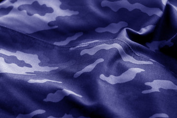 Old camouflage cloth with blur effect in blue tone. © pavelalexeev