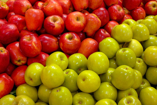 Juicy, fresh, healthy red and green apples. They lie in a continuous layer. Border between green and red - digonal.