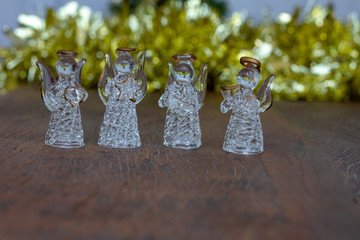 Christmas decoration. Crystal angels ornaments. Golden Tinsel. Wooden Background. Copy Space
