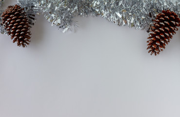 Christmas Frame Decoration. Pines  and a metallic silver tinsel. White background. Copy Space