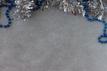 Christmas Frame Decoration. Blue shiny and metallic silver tinsel. Silver metallic glitter background. Copy Space