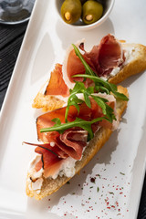 Bruschetta with Parma and goat cheese, olives and almonds. Wine set