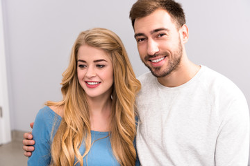 close-up portrait of young couple embracing and looking at camera