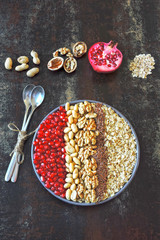 Vegan breakfast bowl of oatmeal, nuts and pomegranate. Healthy breakfast concept.