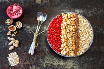 Obraz na płótnie Canvas Vegan breakfast bowl of oatmeal, nuts and pomegranate. Healthy breakfast concept.