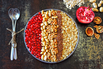 Vegan breakfast bowl of oatmeal, nuts and pomegranate. Healthy breakfast concept.