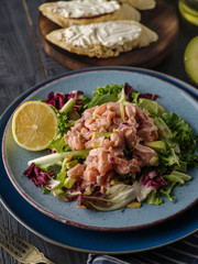 Ceviche is a traditional dish from Peru. Salmon marinated in lemon with fresh lettuce, avocado and onions