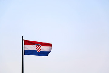 Flag of Croatia, blowing in the wind. Sky in the background, selective focus.
