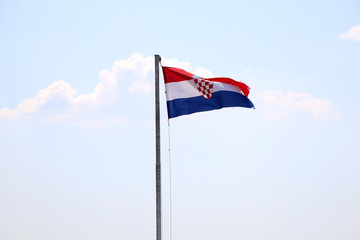 Flag of Croatia, blowing in the wind. Sky in the background, selective focus.
