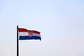 Flag of Croatia, blowing in the wind. Sky in the background, selective focus.
