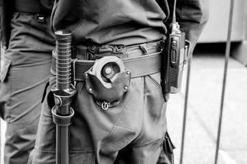 Blur. Police equipment in the cordon against a metal fence. Black and white