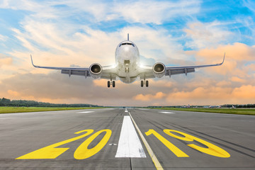 The inscription on the runway 2019, plane taking off. The concept of travel in the new year, holidays.