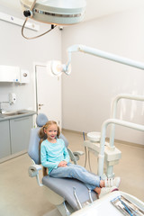 Obraz premium high angle view of adorable little child sitting in dental chair at dentist office