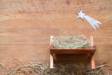 Manger and star of Bethlehem abstracy christmas background nativity scene on wooden board
