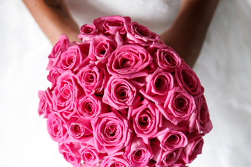 Bouquet di colore rosa  shocking tenuto in mano  da una sposa