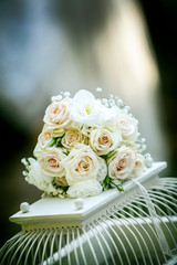 Bouquet da sposa  di rose bianche sopra gabbietta  per uccellini