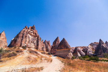 Erosion of many rocks in the desert. Dry and hot. Touristic place Cappadocia. Landscape of huge rocks and hills