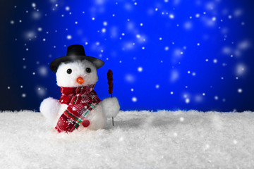snowman in the snow with copy space. christmas background with falling snow.