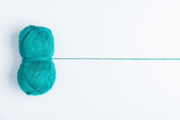 top view of blue yarn ball for knitiing on white backdrop