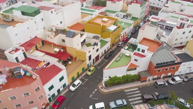 TENERIFE, PUNTA BRAVA, SPAIN - MAY, 18, 2018: Aerial view colorful houses of small town on the coast
