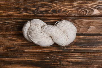 top view of white yarn clew for knitting on wooden surface