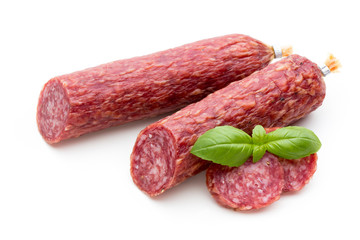 Salami smoked sausage, basil leaves and peppercorns isolated on white background.