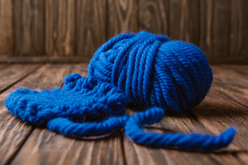 close up view of blue yarn for knitting on wooden surface