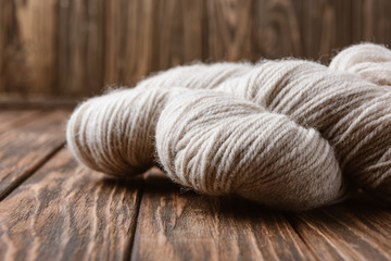 close up view of white yarn for knitting on wooden surface