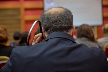 Headphones grab hold of your ears and listen . bald security guard with the headset to control people . heated debate at a conference discussion