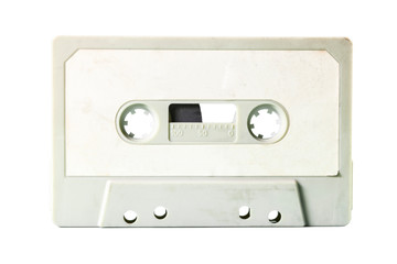 An old vintage cassette tape from the 1980s (obsolete music technology). White label, light gray plastic body, isolated.