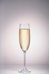 close up view of glass of champagne on grey backdrop