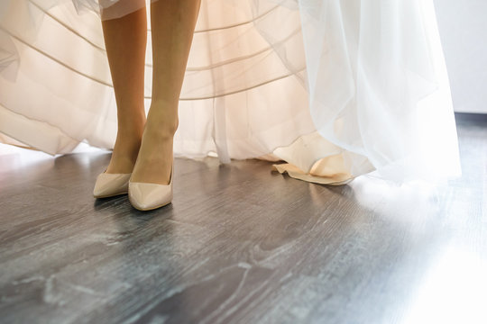 legs of a young bride in a white dress