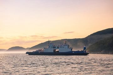 Fototapeta premium Ferry crossing Saguenay river at dusk, Quebec, Canada
