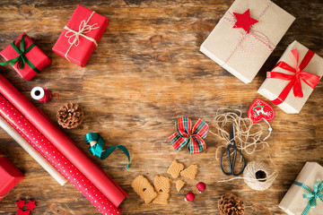 DIY Gift Wrapping. Beautiful red christmas gifts on rustic wooden table. Top view of christmas...