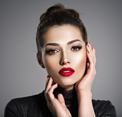 Beautiful woman with bright make-up and red nails.