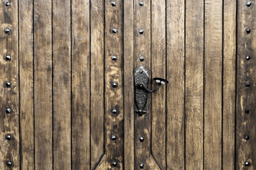 part of an old dark wooden antique door with metal elements