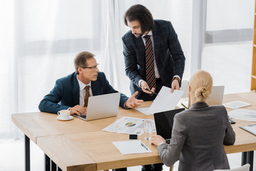 insurance agent showing contract to workers in office