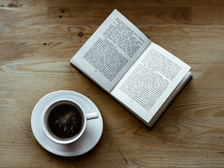 cup of coffee and book on table. 