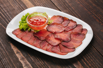 White plate with dried  mieat slices as beer snack