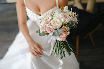 Obraz na płótnie Canvas Bride with a beautiful wedding bouquet in light colors