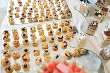 Candy bar with small cakes in light colors