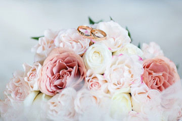 wedding golden rings with pastel pink rose