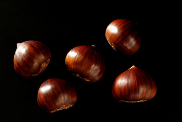 close up on sweet chestnuts on black background