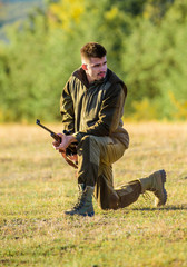 Man charging hunting rifle. Hunter khaki clothes ready to hunt hold gun mountains background. Hunting shooting trophy. Hunter with rifle looking for animal. Hunting as male hobby and leisure